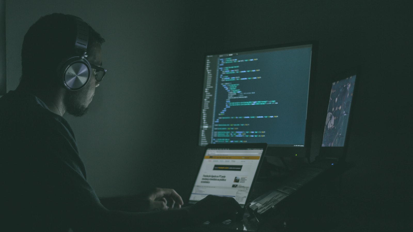 A person working across multiple laptops, representing discovery of ungoverned AI usage